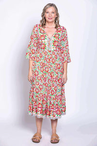 Woman in Oma floral batik dress looking forward, arms at sides
