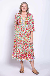 Woman standing in floral batik midi dress, front view with relaxed posture