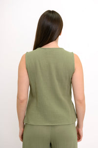 Woman wearing a green sleeveless top, wide-leg pants against, against a white background, back view