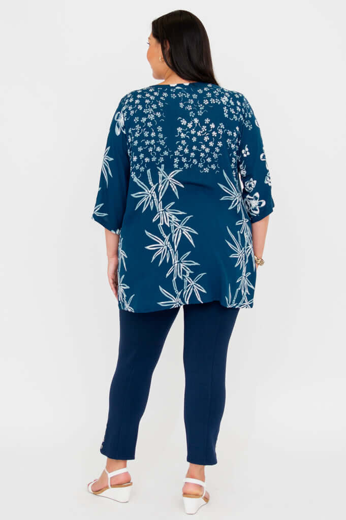 Back view of woman in indigo bamboo print blouse and navy pants