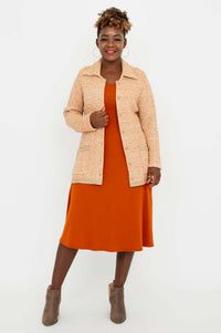 Full front view of model in Chanel Cardigan and orange dress with taupe ankle boots