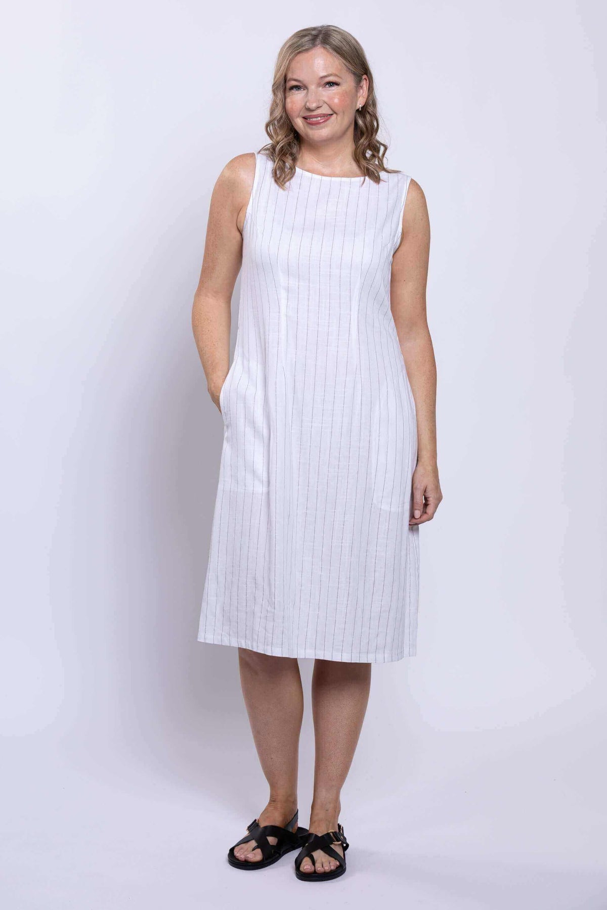 Woman in white striped dress showing side pocket detail
