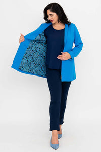 Woman showing patterned inner lining of bright blue thigh-length coat