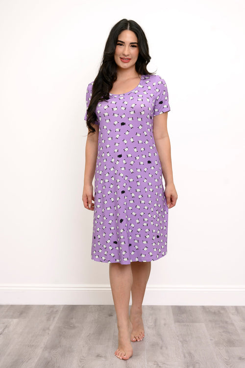 Fully body front view of woman wearing a purple dress with white sheep print