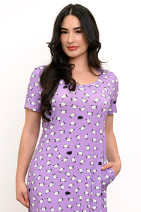 Close up view of woman with her hand in the pocket of her purple sheep print dress