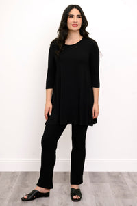 Full body front view of woman modelling a black round neck tunic, black slim fit pants, and black shoes
