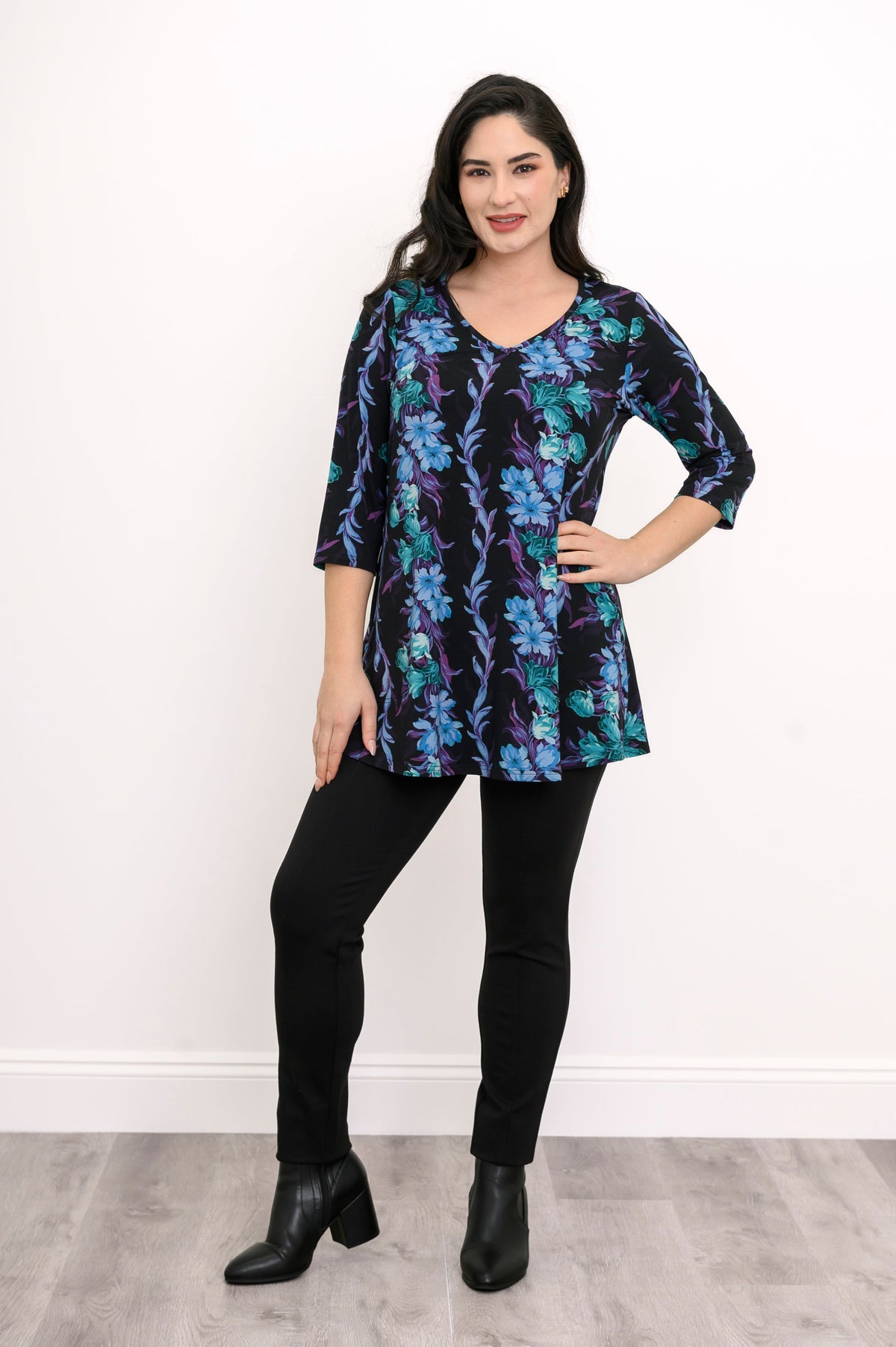 Smiling model in a teal floral patterned bamboo top, showcasing a relaxed fit and flared A-line silhouette.
