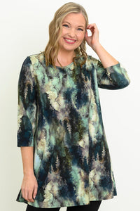 Front view of a female model wearing a blue-green watercolor forest print A-line tunic with 3/4 sleeves, against a white backdrop