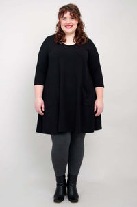 Plus size model in black A-line tunic with patch pockets and grey leggings
