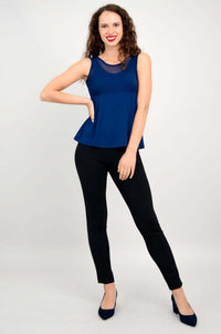 Woman posing in navy sleeveless tank with mesh panel and black pants