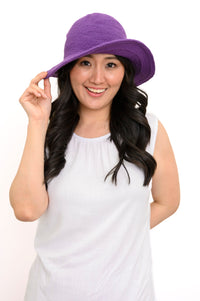 Woman wearing a purple hat on a white background