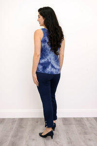 Back view of model in a blue tie-dye tank top and navy pants against a white background