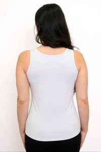 Back view of woman wearing a white slim fit tank top and black pants against a white background