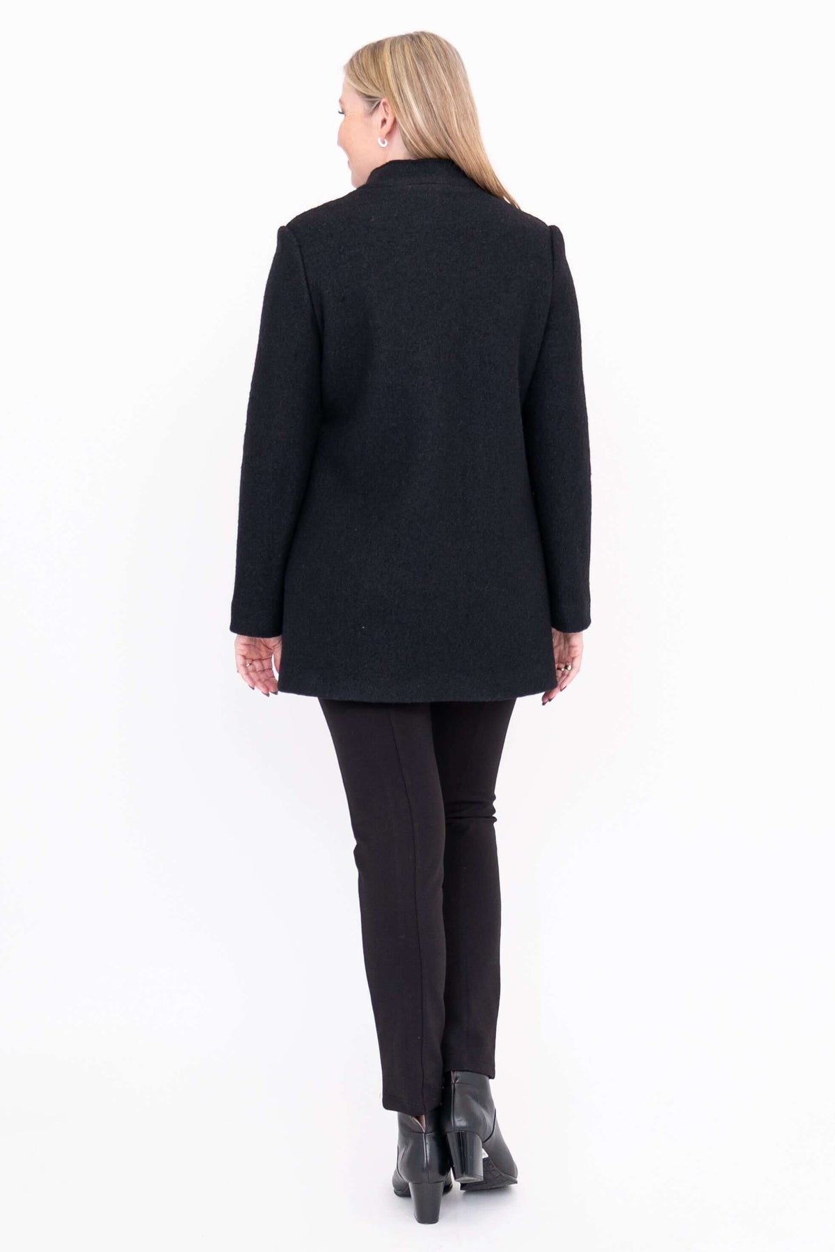 Rear view of woman wearing black boiled wool coat and black pants