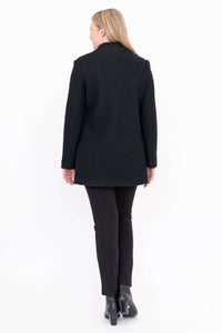 Rear view of woman wearing black boiled wool coat and black pants