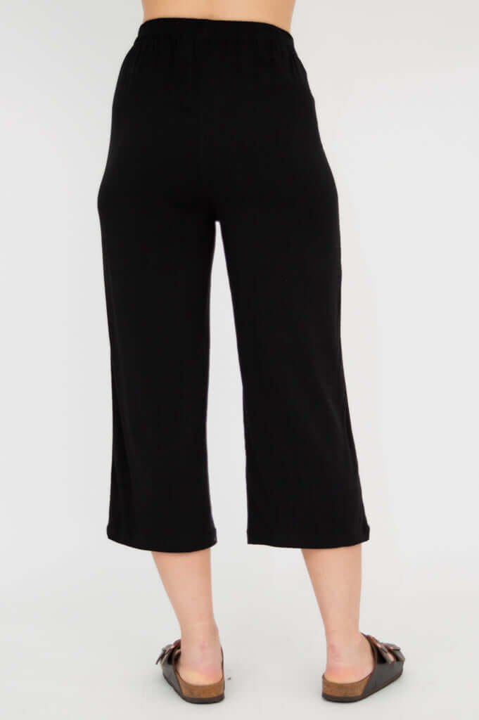 Rear view of black capri pants on model