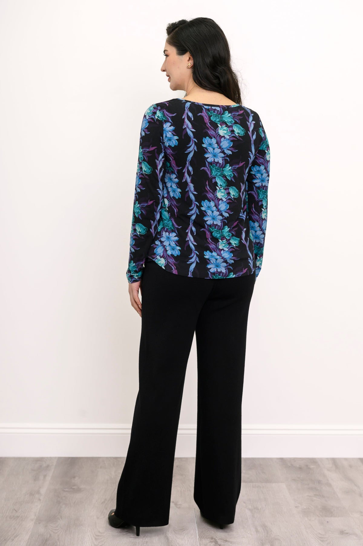 Back view of a teal and black floral print bamboo tunic, showcasing a relaxed-fit drape and curved hemline.