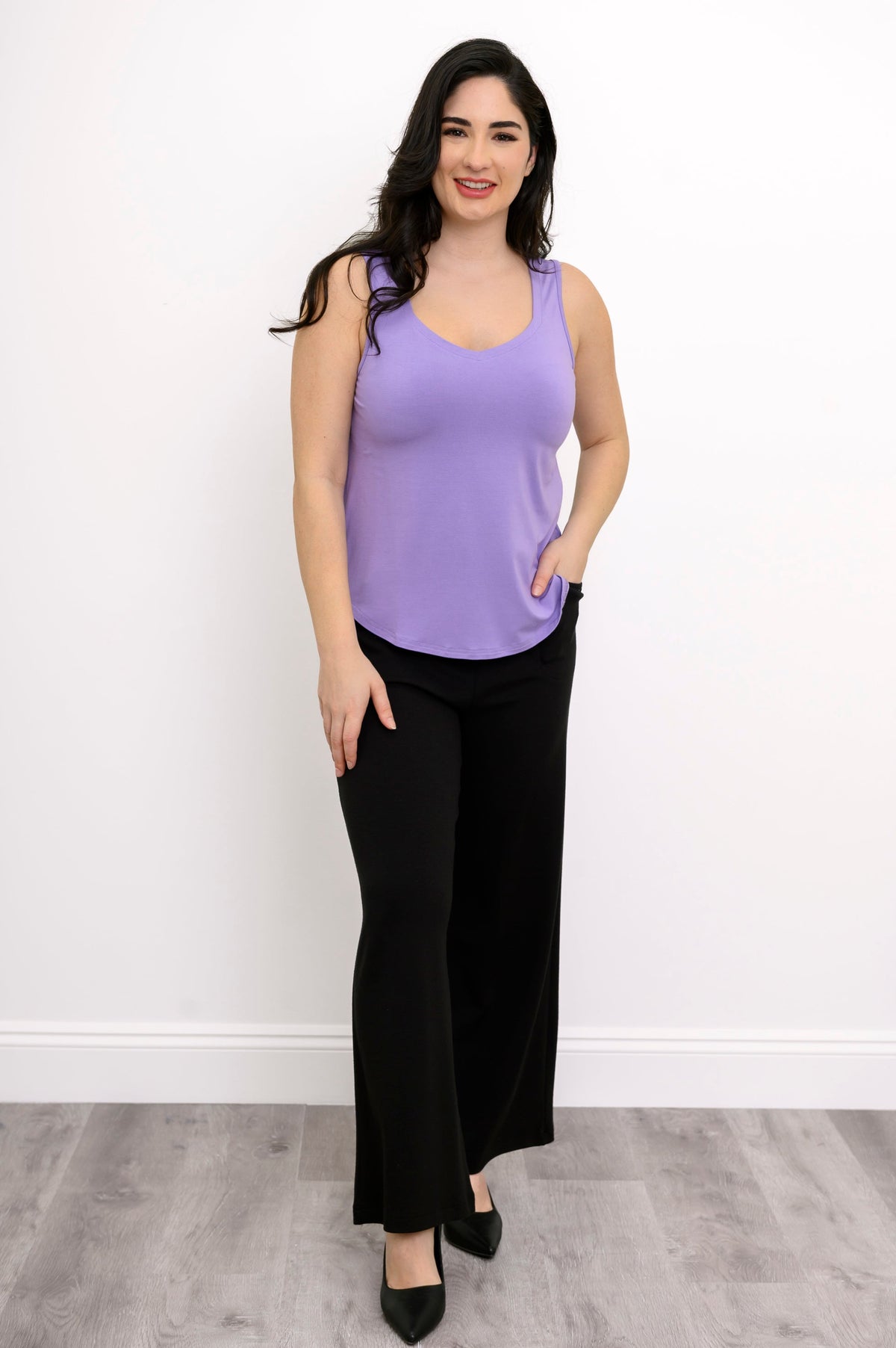 Front view of woman wearing loose-fit lavender tank and black trouser with pockets