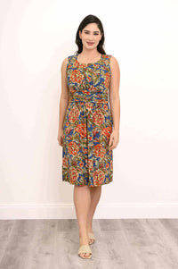 Woman wearing sleeveless knee-length floral dress with ruched bodice, front view