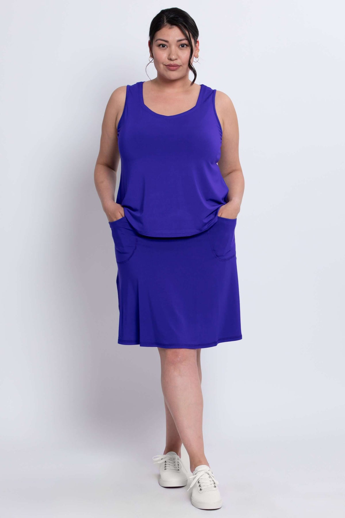 Model wearing a royal blue Magna Skort and matching tank, hands in pockets