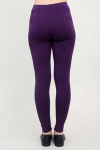 Back view of a person wearing plum bamboo leggings with black slip-on shoes