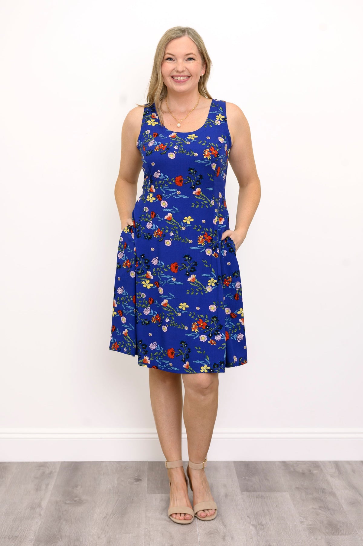 Front view of woman wearing a blue and red floral dress against a white background