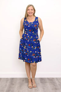 Front view of woman wearing a blue and red floral dress against a white background