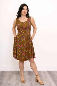 Woman in brown floral dress with hands in pockets