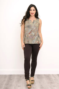 Full body view of woman wearing green floral sleeveless top, brown pants, and sanals