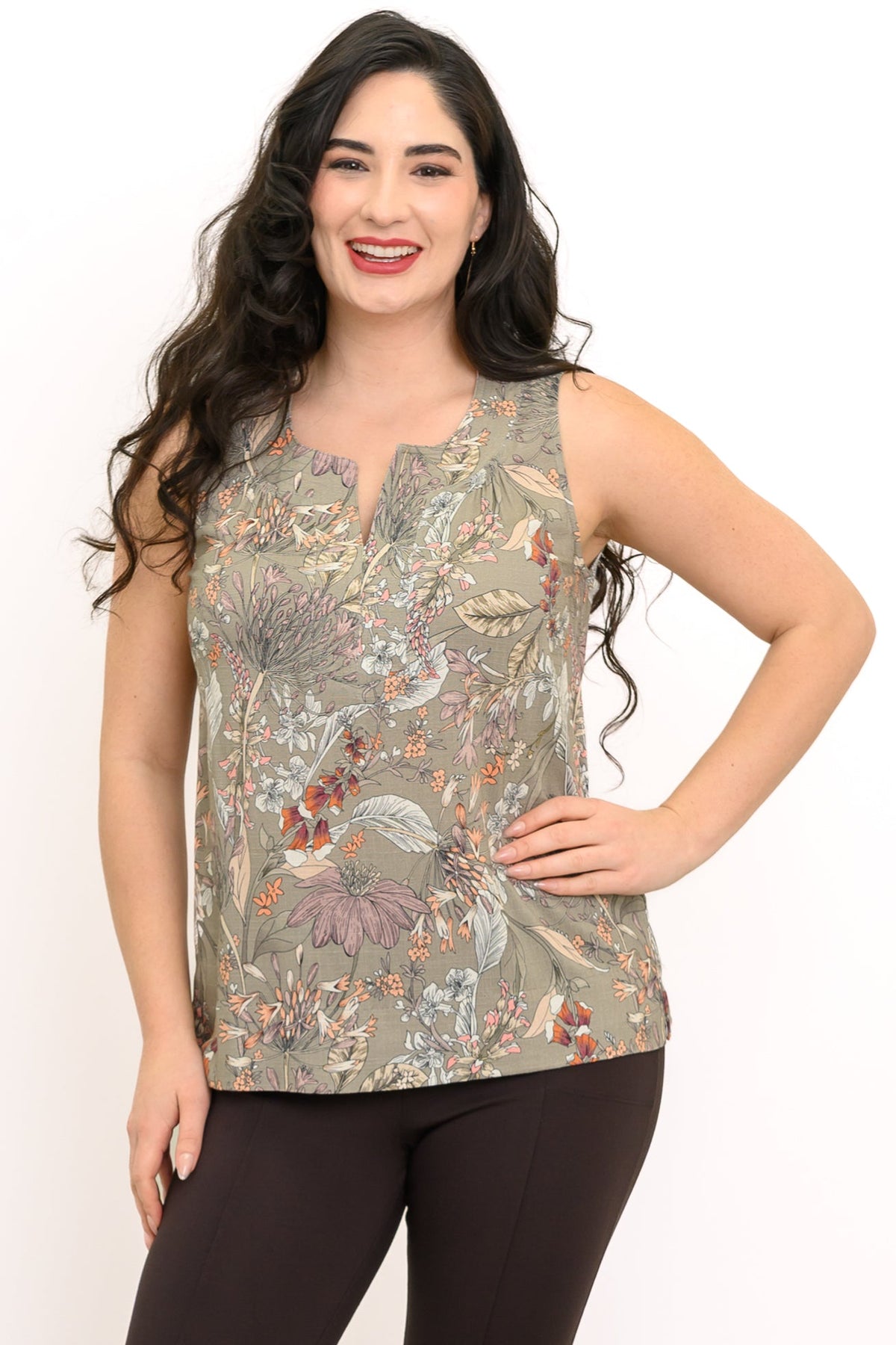 Woman posing with her hand on her hip wearing a sleeveless green tank top with neutral floral pattern