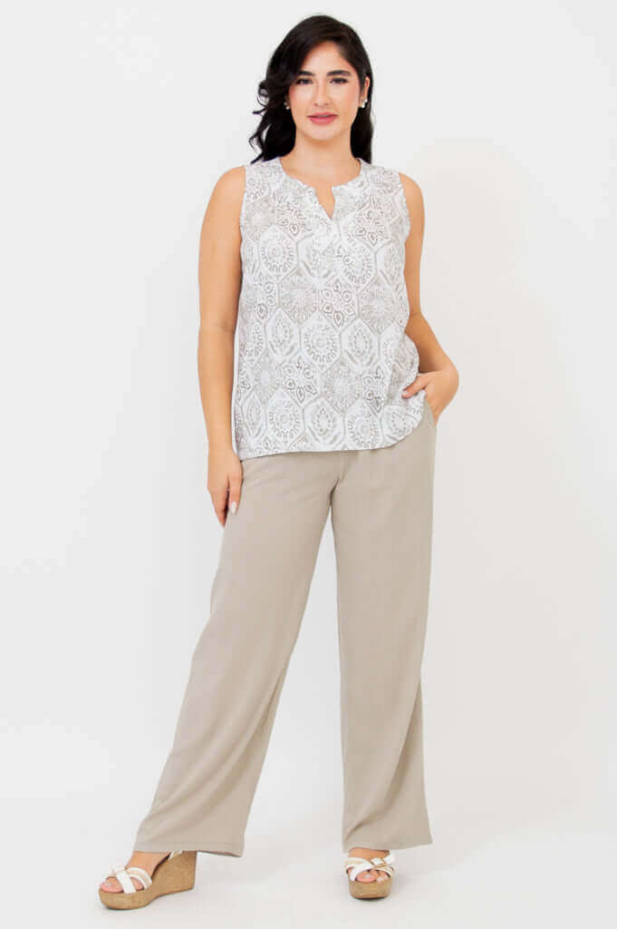 Full body view of model in Scarlette tank and wide-leg beige pants, one hand in pocket