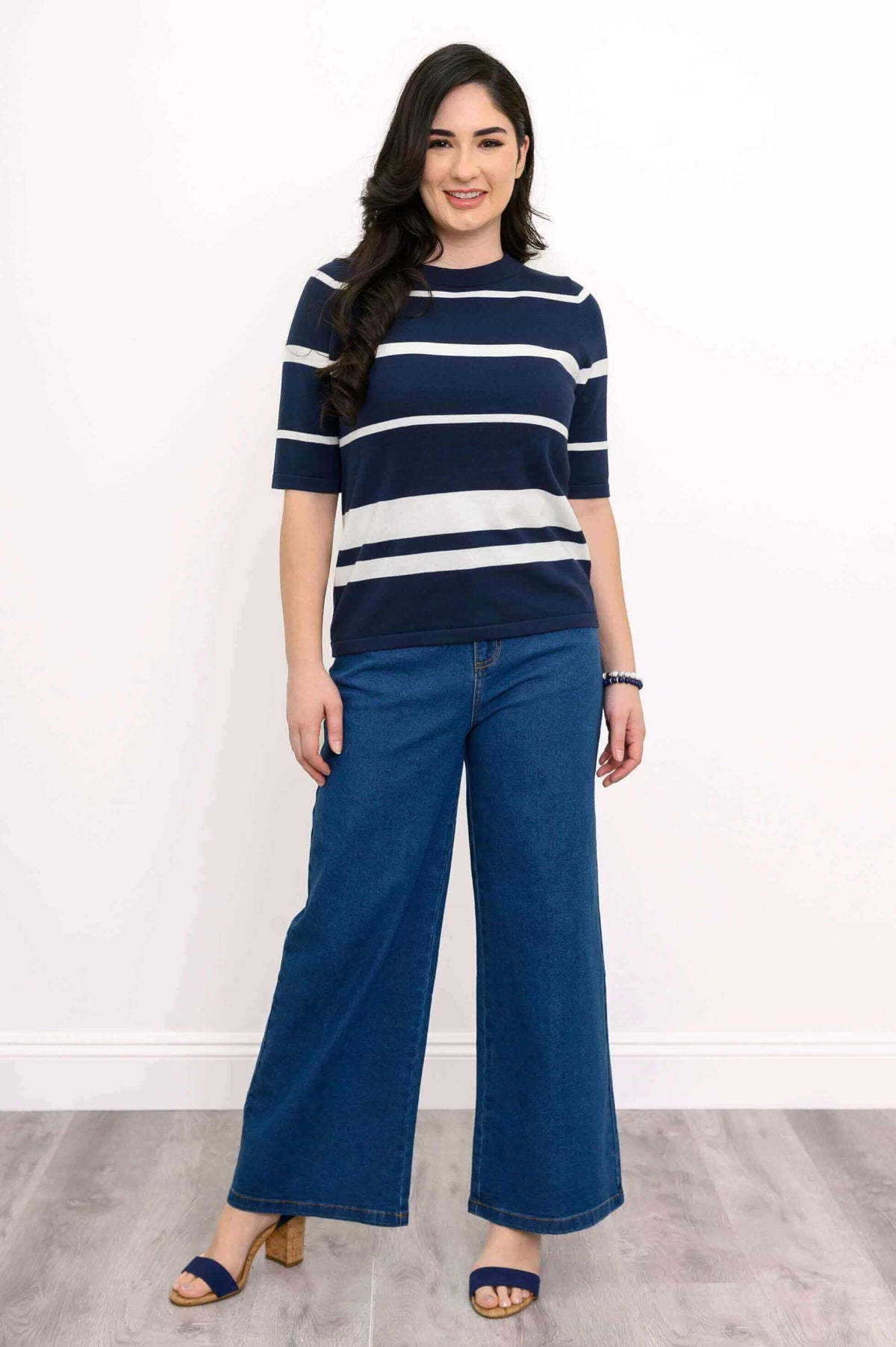 Woman smiling in navy and white striped Serena Sweater and blue jeans, facing forward
