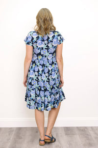 Back view of woman wearing a floral dress with a white background