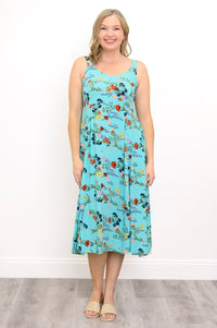Woman wearing a teal floral dress and sandals against a white background, front view