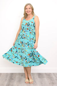 Woman wearing a blue floral dress against a white background, front view