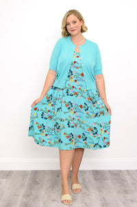 Woman wearing a light blue floral dress with a light blue cardigan on a white background, front view