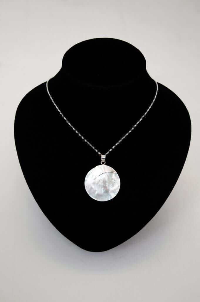 Sterling silver shell pendant necklace displayed on a black necklace bust