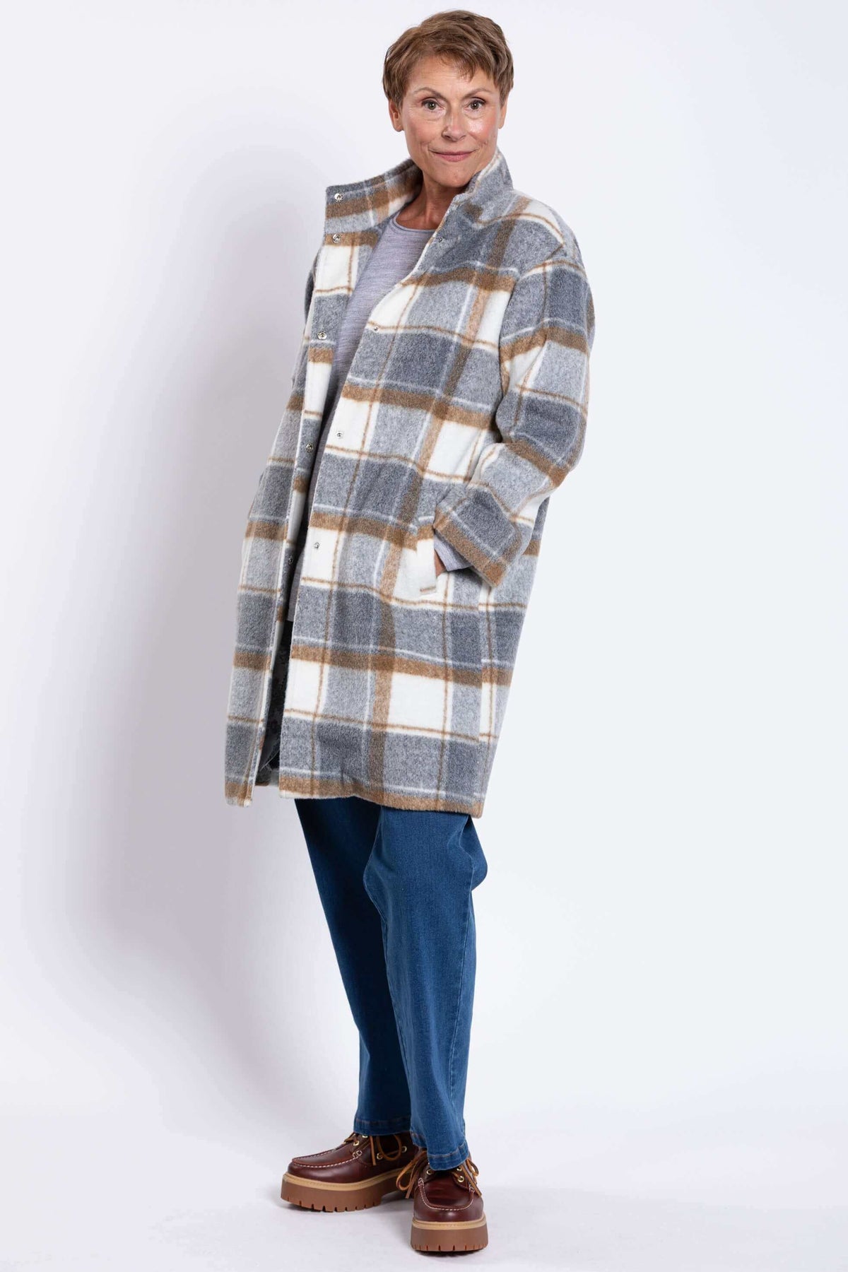 Side angled pose of woman in cozy plaid wool coat
