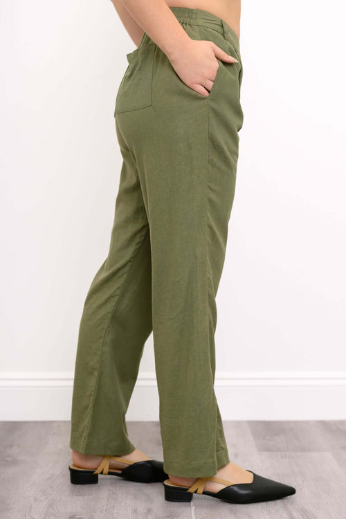 Side view of model featuring elasticized back waistband and side pocket of trousers