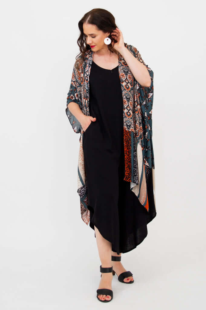 Model turning slightly, showcasing side of Darcy kimono wrap with geometric and floral print