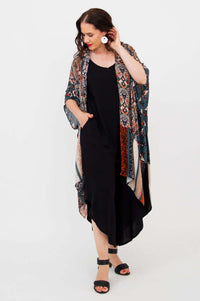 Model turning slightly, showcasing side of Darcy kimono wrap with geometric and floral print
