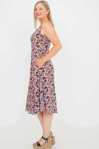 Side view of model in vibrant floral sleeveless dress with pockets