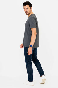Side view of man in dark grey V-neck T-shirt and jeans looking back