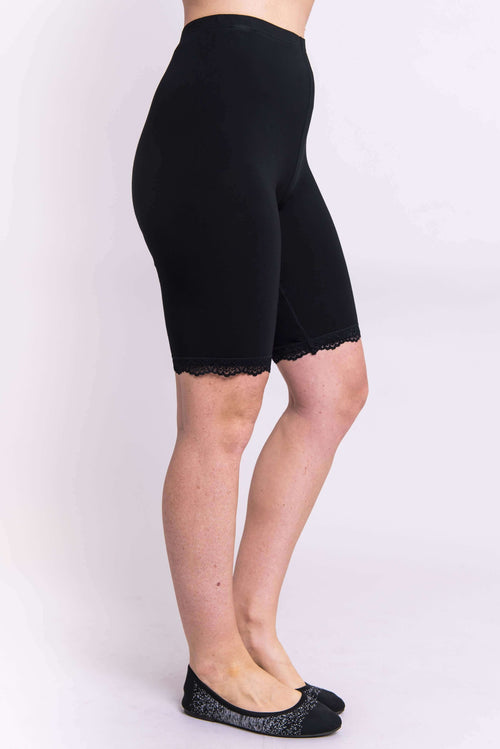 Side view of woman wearing black bamboo undershorts with lace trim