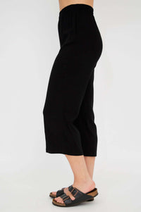 Side view of model in black capri pants and sandals