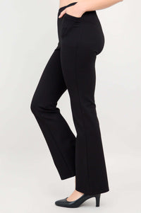Side view with model's hand in pocket, displaying sleek fit of black pants