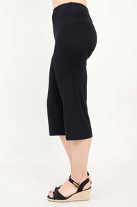Side view of black yoga capri pants showing fit and length on a woman