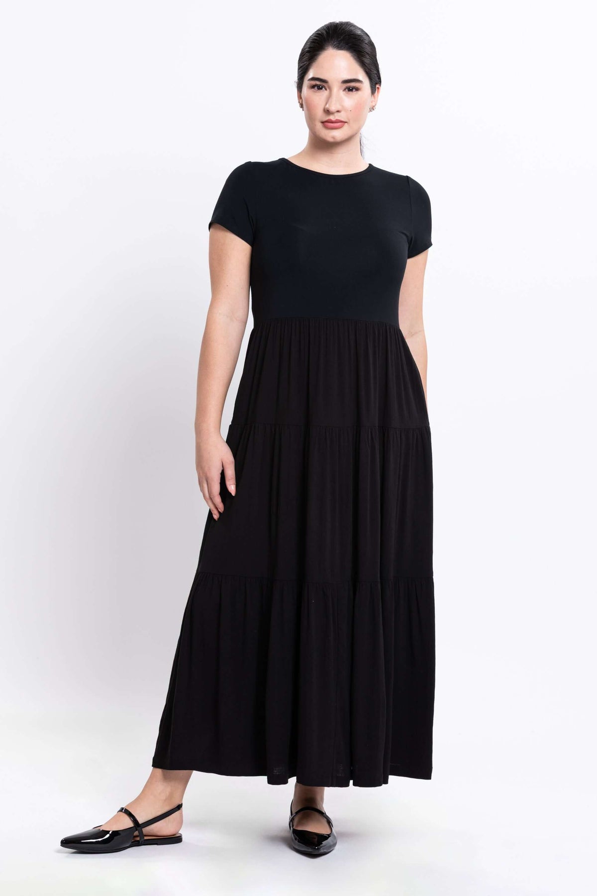 Angle view of woman in black empire waist maxi dress