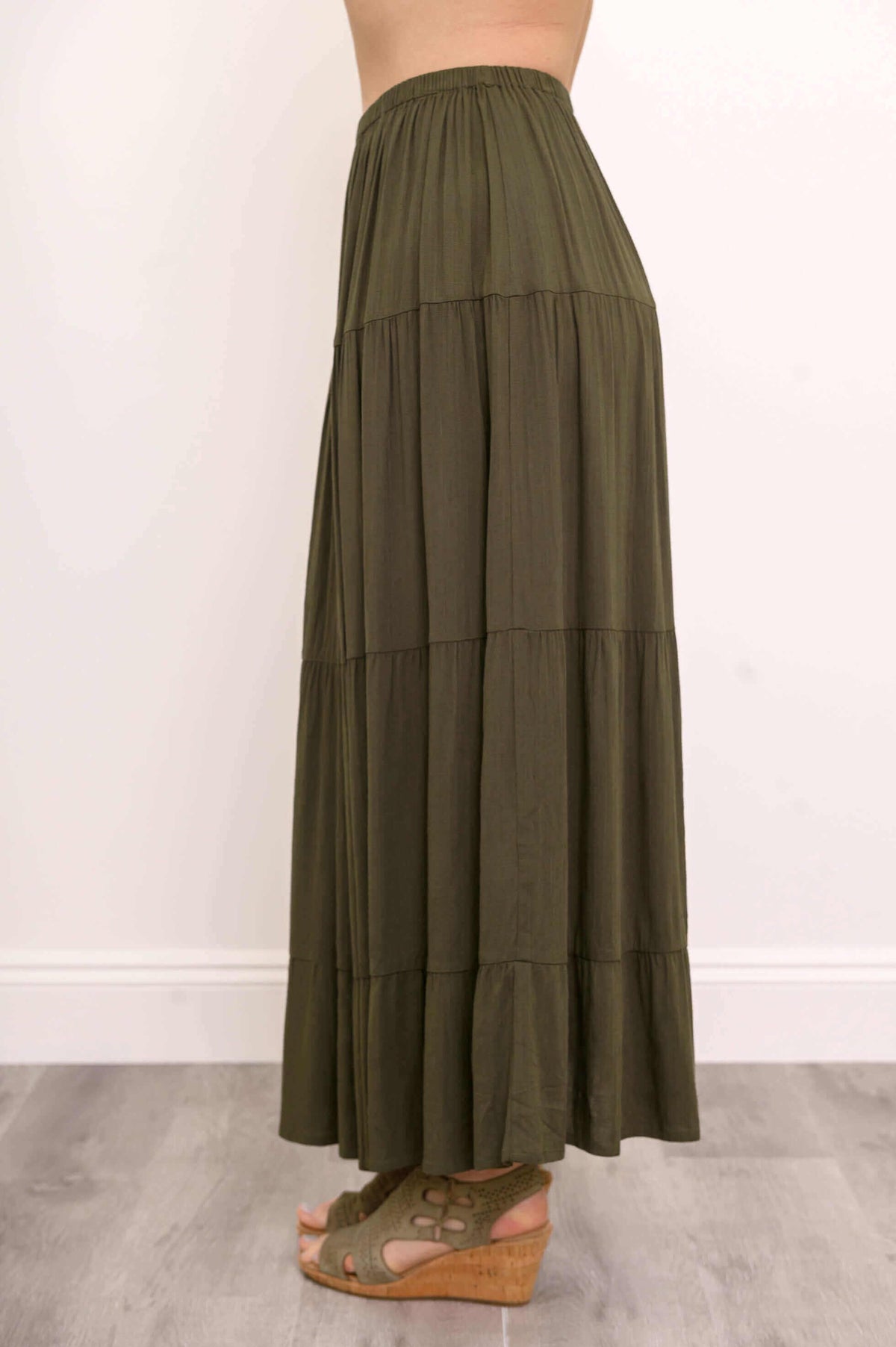 Side view of olive green tiered maxi skirt showing layered detailing