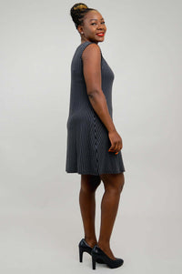 Side view of woman in a black and white pinstripe sleeveless shift dress